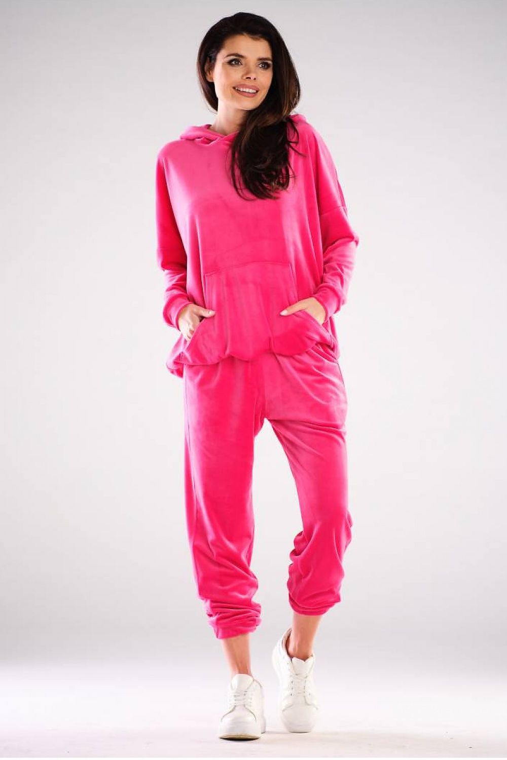 Vibrant pink velvet pullover with hood and large pocket, showcasing a casual urban style, designed and made in Poland.