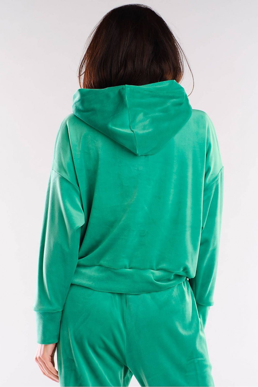 Model wearing green velour hoodie, classic loose fit perfect with jeans. Designed and made in Poland. Polyester-Spandex blend.