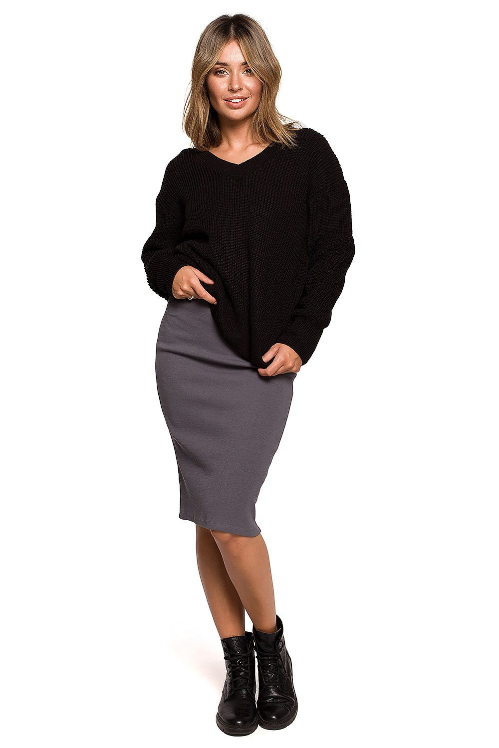 Woman wearing black oversized V-neck pullover and pencil skirt, perfect for autumn fashion and warmth.