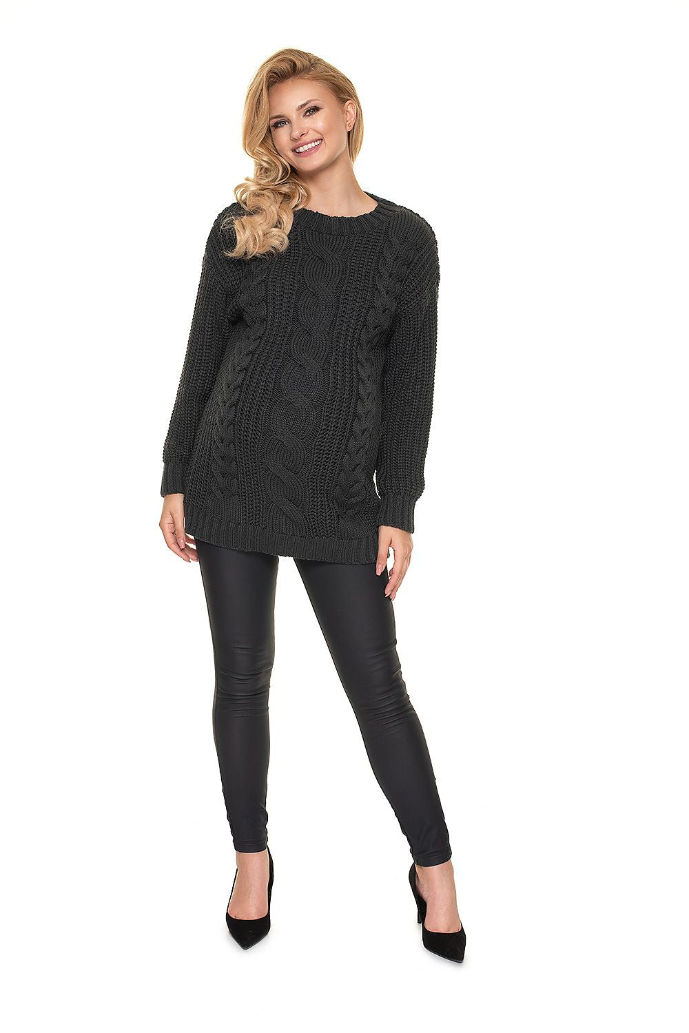 Model wearing PeeKaBoo maternity pullover 157830 with cable knit design, black leggings, and heels. Stylish and cozy for moms.