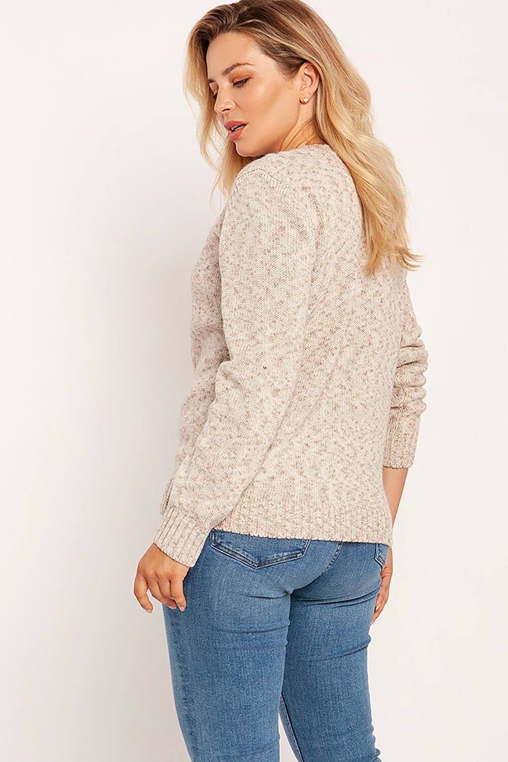 Woman wearing a melange knit pullover with round neckline, paired with jeans; perfect for autumn-winter fashion.