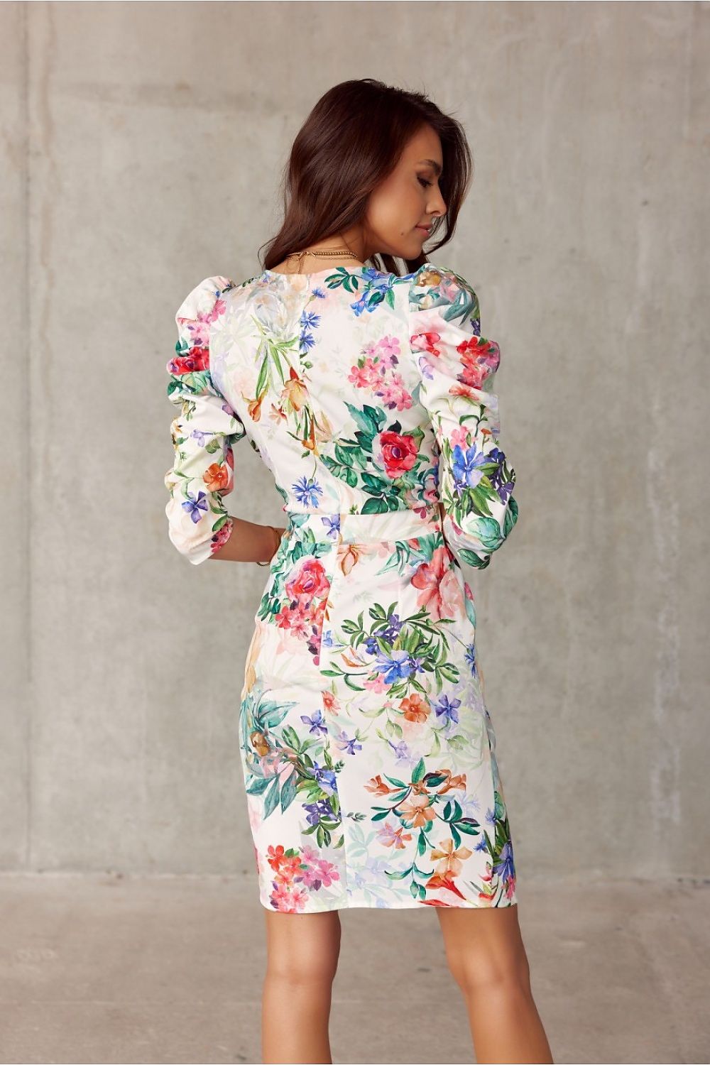 Woman wearing floral knee-length dress with puffed shoulders, showcasing stylish Roco Fashion design.