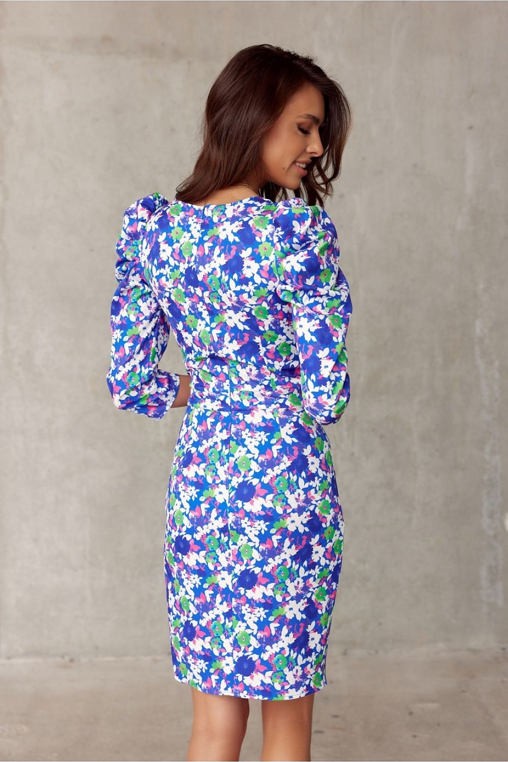 Woman wearing floral knee-length dress with puffed shoulders, showcasing style and comfort by Roco Fashion.